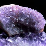 Close-up of a stunning purple amethyst geode showcasing natural crystal formations.